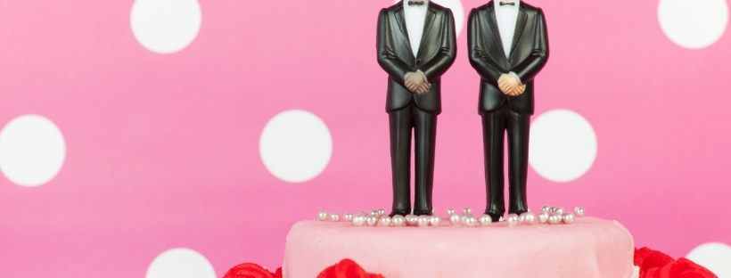 The figures of two men sit atop a wedding cake
